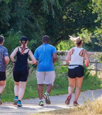 Four people running through the park