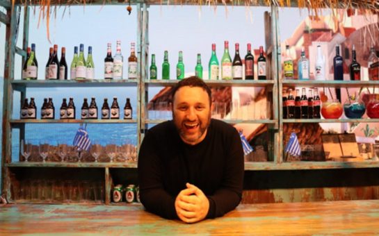 Antony Costa leaning over a bar