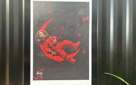 Image shows baby in astronaut suit sleeping on the moon - both are coloured red on a black background.