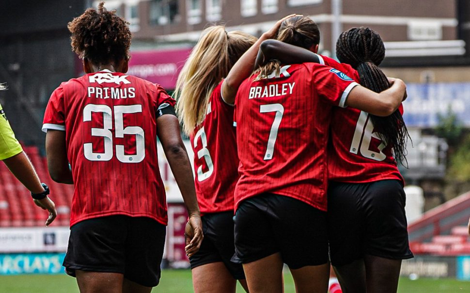 The back of Atlanta Primus in her 35 shirt, alongside a huddle of Charlton women's teammates.