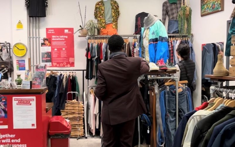 A man with his back to the camera shopping in a Crisis charity store