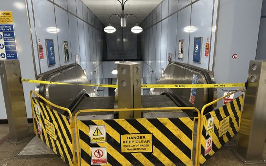 Danger Keep Clear sign in front of two escalators at Cutty Sark station